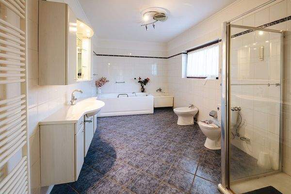 Großes Bad mit Whirlpoolbadewanne und Dusche im EG