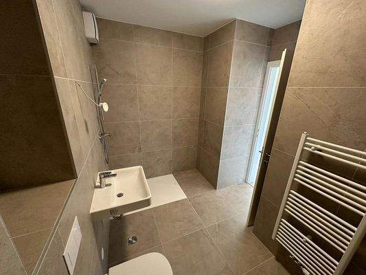 Vollständig gefliestes Badezimmer mit ebenerdiger Dusche