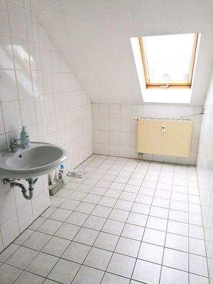 gefliestes Bad mit Wanne und Fenster