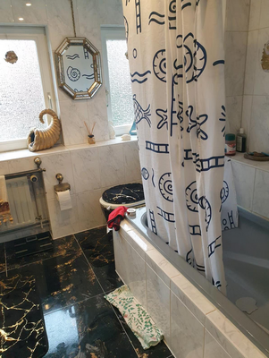 Badezimmer mit Badewanne, Tageslicht und klassischer Ausstattung