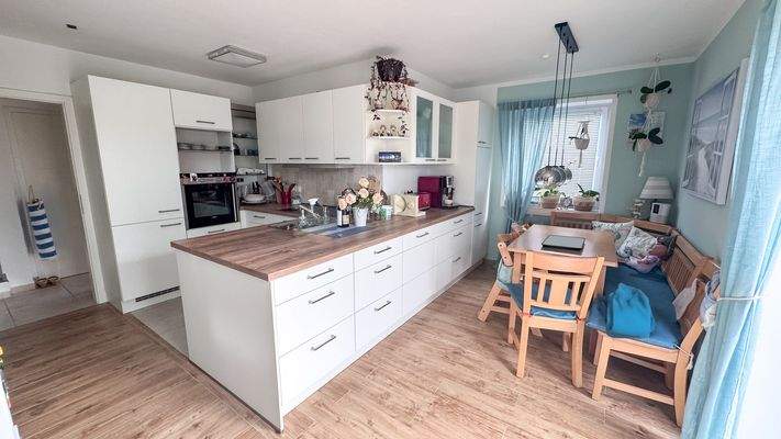 Offene Küche mit Essbereich und Zugang zur Terrasse