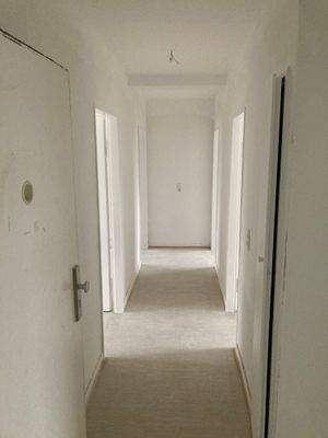 Flur mit weiß angelegten Wänden und hellem Vinylboden