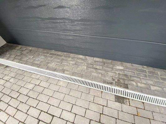 Vor dem Garagentor eine sogenannte ACO-Drainage