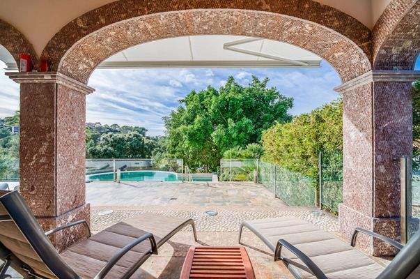 Überdachte Terrasse mit Poolblick