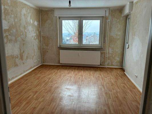 Schlafzimmer/Wohnzimmer mit PVC-Bodenbelag in Holzoptik mit tapezierfähigen Wänden.