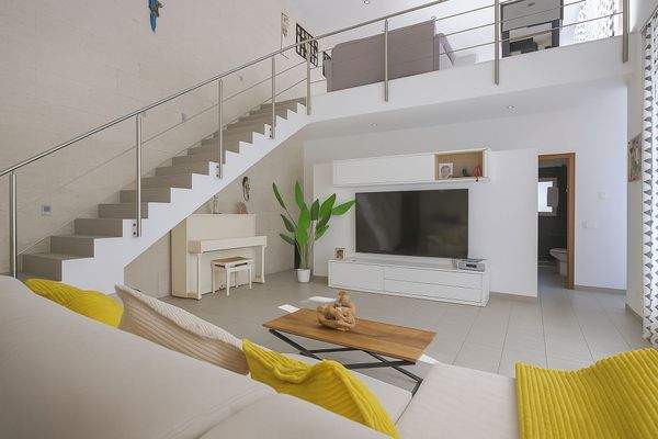 Wohnbereich mit Galerie und moderner Treppe.