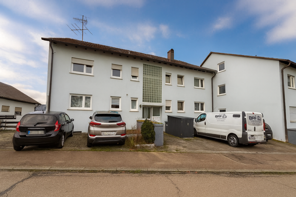 Zweifamilienhaus mit geparkten Fahrzeugen