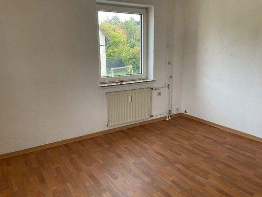 Zimmer mit Fenster und Boden in Holzoptik