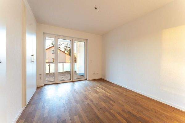 Schlafzimmer mit Zugang zum teilüberdachten Balkon