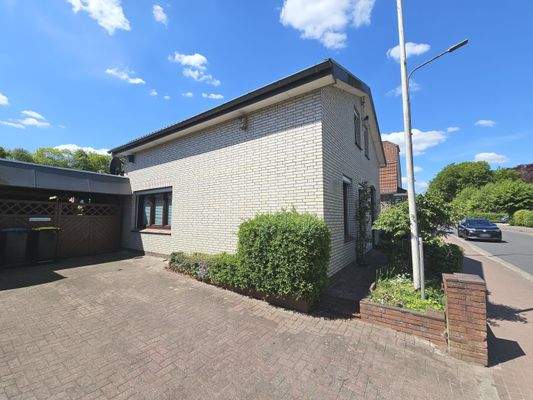 Linke Traufenansicht mit Carport und Stellplatz