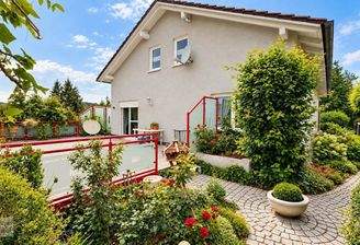Gepflegtes Haus mit blühender Gartenterrasse