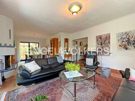 Wohnzimmer mit angrenzendem Esszimmer und Kamin
