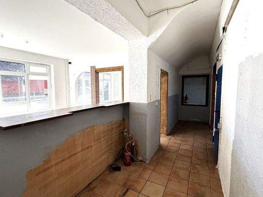 Blick hinter den Tresen mit Zugang zur Küche und zu den WC's