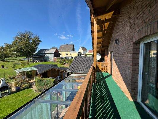 Blick vom Balkon auf Nebengebäude im Garten