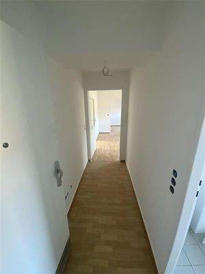 Flur mit braunem PVC Boden und weißen Wänden.jpg