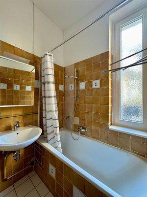 Badezimmer mit Wanne und Fenster