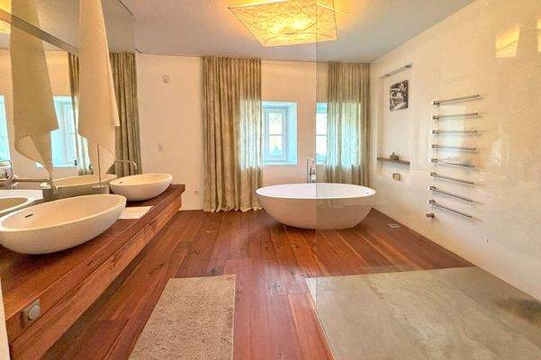 Das Badezimmer mit freistehender Badewanne und Regendusche