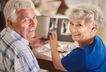 cheerful-senior-couple-browsing-album-with-their-p