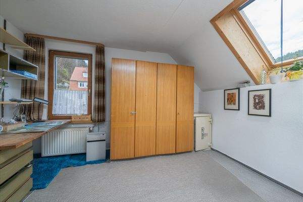 Helles Dachzimmer mit praktischem Stauraum und großem Dachfenster