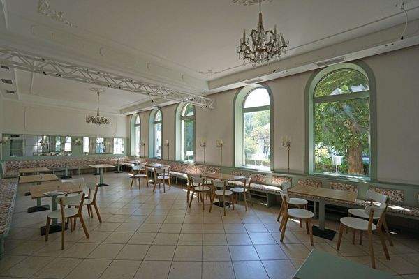 Gastraum mit Deckenstuck und großen Rundbogenfenstern