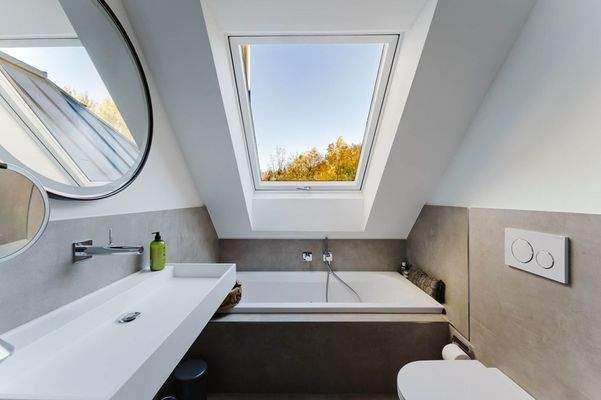 Das hochwertig ausgestattete Badezimmer mit Badewanne und Regendusche 