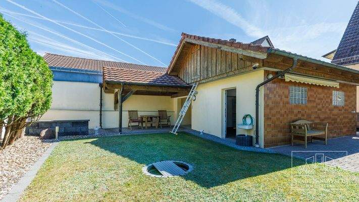 Überdachter Freisitz im Garten hinter der Garage