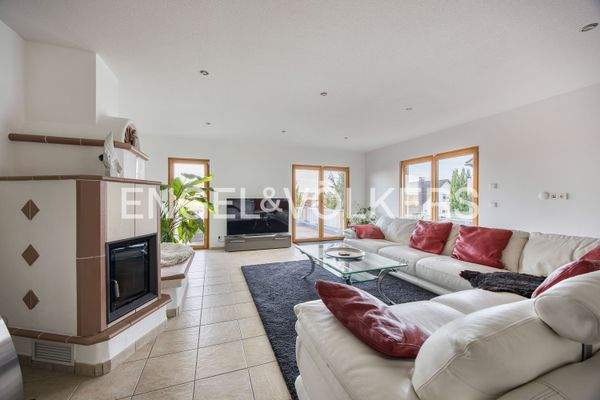 Wohnbereich mit wärmenden Kamin und direktem Zutritt auf die großzügige Dachterrasse