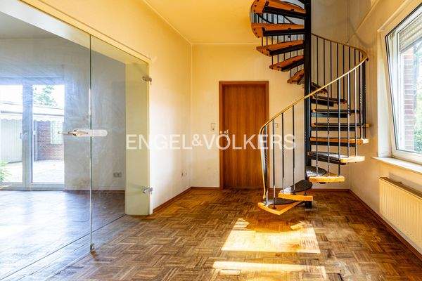 Helles Treppenhaus mit geschwungener Holztreppe