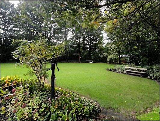 Die harmonische Anordnung von Pflanzen und Bäumen verleiht dem Grundstück eine friedliche Atmosphäre