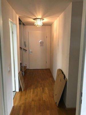 Wohnungsflur mit Parkettboden und weißen Wänden