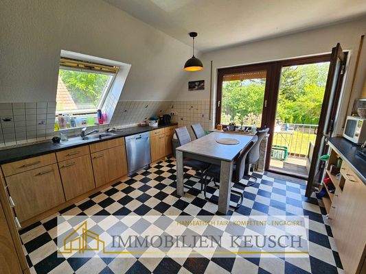 Große Küche mit Sitzgelegenheit und Zugang zum Balkon OG