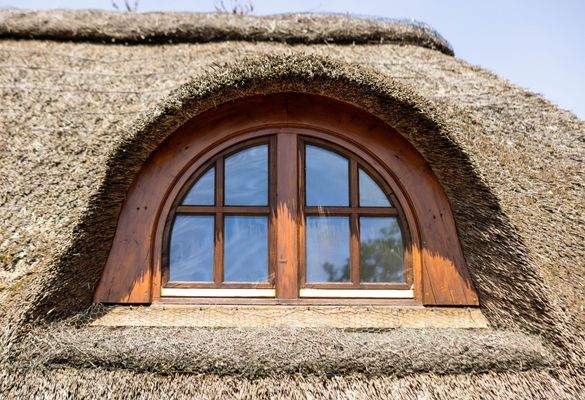 Rundes Fenster im Strohdach