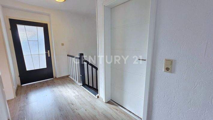 Flur im OG mit Zugang zum Bad und Balkon