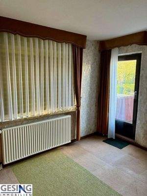 Zimmer im Obergeschosss mit Zugang zum Balkon 