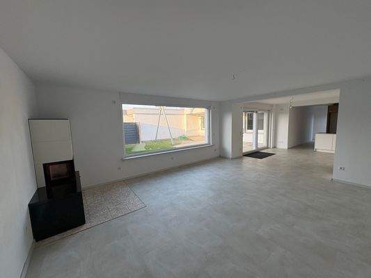 Wohn-Esszimmer mit Kamin und offener Küche