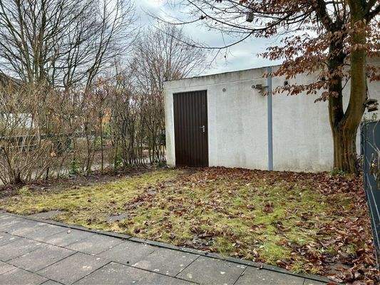 Terrasse mit Gartenbereich und angrenzender Garage