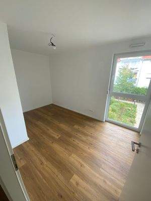 Weiters Kinderzimmer mit weißen Wänden und Vinylboden mit Holzoptik.JPG