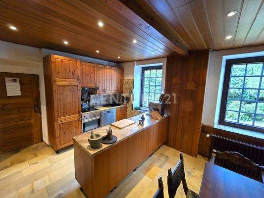 Stilvolle Einbauküche mit Zugang zum Vorratsraum