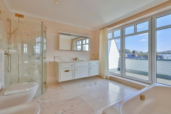 luxuriöses Badezimmer mit bodentiefen Fenstern und Terrasse