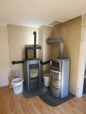 Pellet- und Holzofen mit Warmluftschächten im Wohnzimmer 