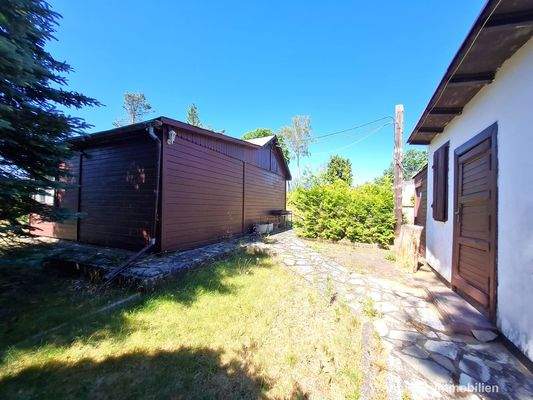 Blick von den Nebengelassen zur Holzlaube