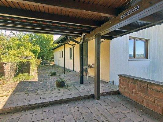 Blick vom überdachten Freisitz auf die Terrasse