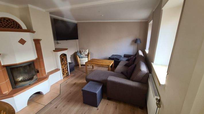 Blick Wohnzimmer mit Kachelofen EG im Haupthaus
