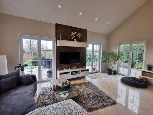 helles Wohnzimmer mit großen Fenstern 