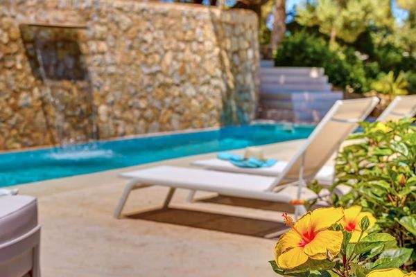 Außenbereich mit Pool und bequemen Sonnenliegen