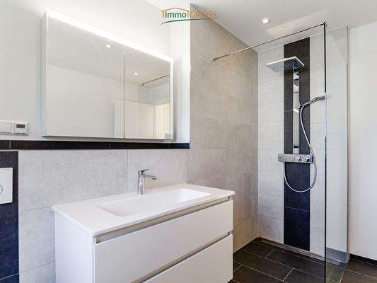 Badezimmer mit bodentiefer Dusche und Badewanne