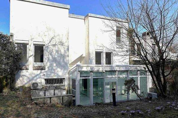 Architektonische Rückansicht mit Wintergarten und gewachsenem Garten