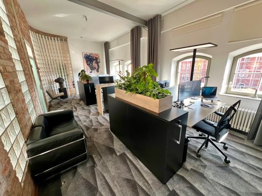 Büro mit vier modernen Arbeitsplätzen und LC2 Besuchersofa