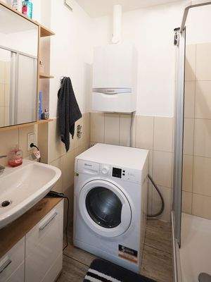Badezimmer mit Dusche und Platz für die Waschmaschine