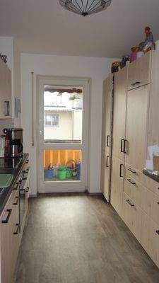 Küche mit Einbauten beidseitig und Balkon